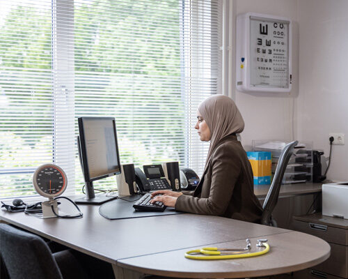 Doktersassistent werkt achter computer